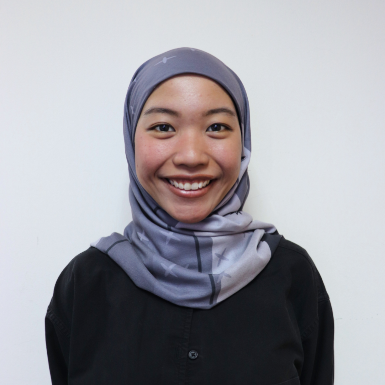 Smiling woman in hijab, showcasing modern fashion and confident expression, perfect for professional and casual settings.