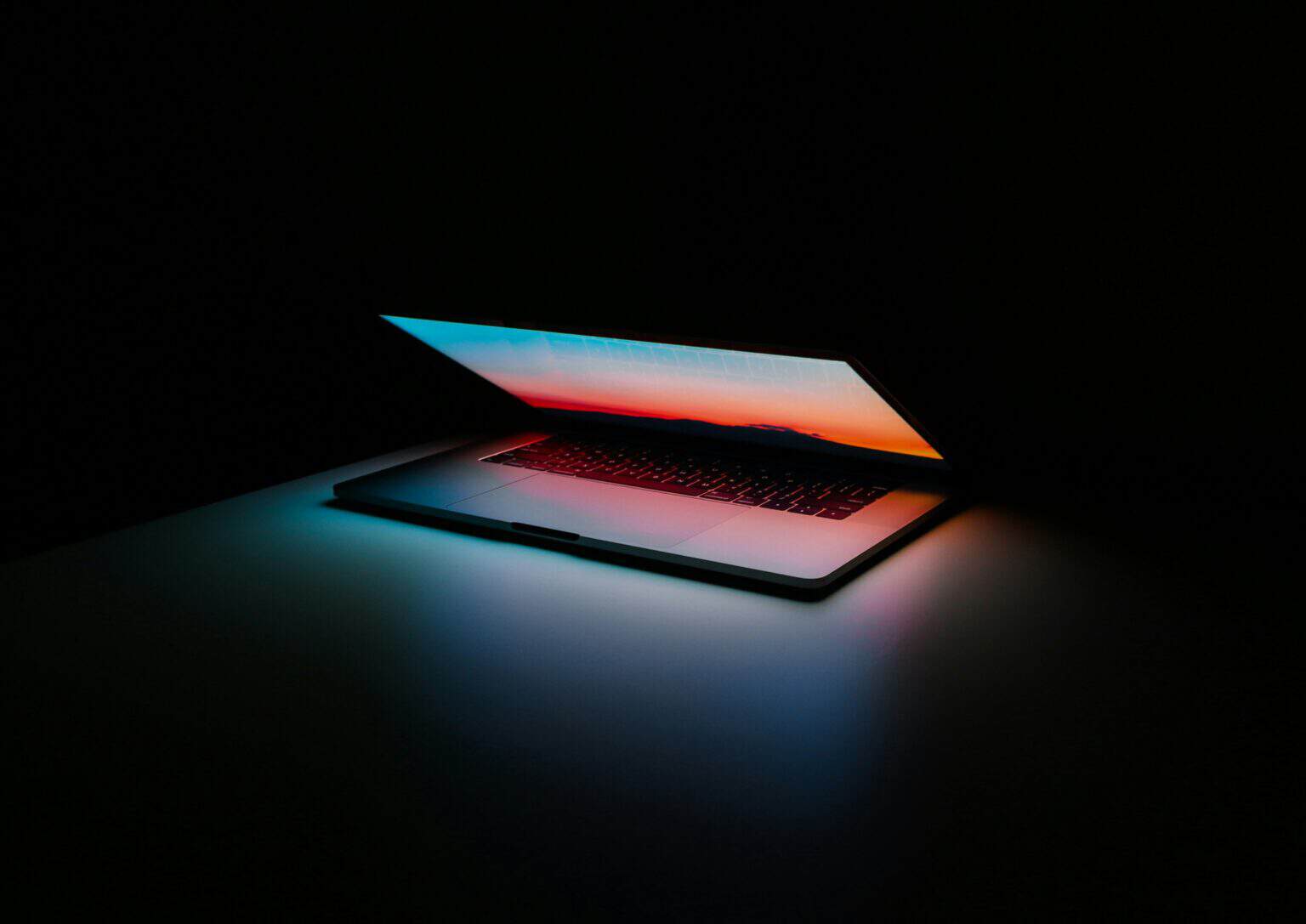 Modern laptop with illuminated screen in a dark environment.