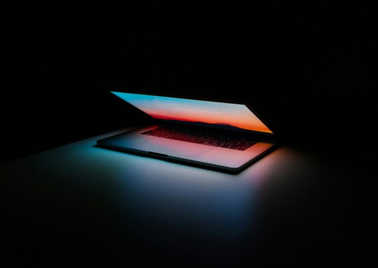 Modern laptop with illuminated screen in a dark environment.