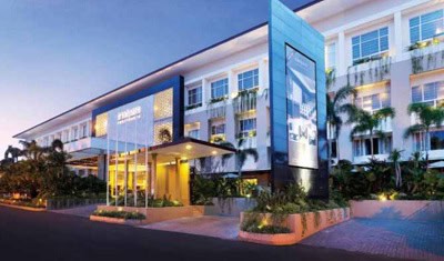 Modern office building with glass façade and lush landscaping in a corporate setting.