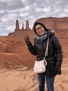A woman in winter clothing enjoying a desert landscape at Monument Valley, Arizona.