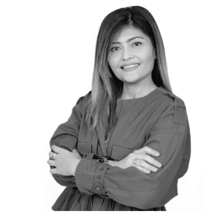 Confident woman with crossed arms, smiling, in a professional setting, monochrome image.