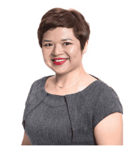 Confident professional woman with short brown hair and bright red lipstick, smiling warmly.