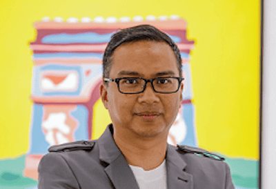 Modern professional portrait of a man in glasses with colourful art background, representing contemporary digital art.